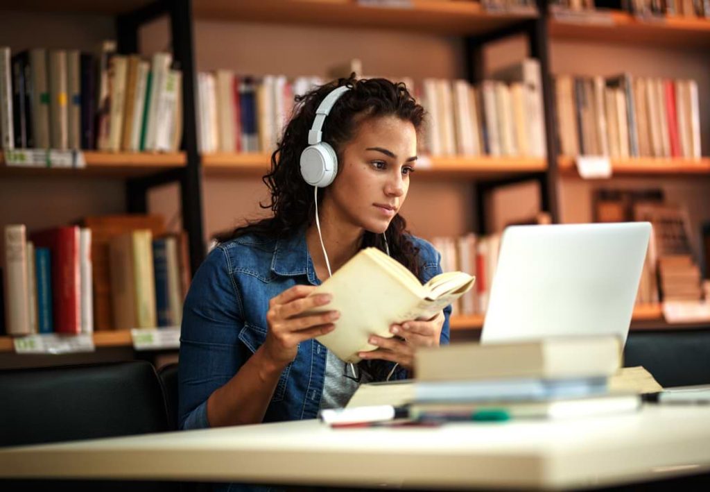 Kvinna som studerar på ett bibliotek